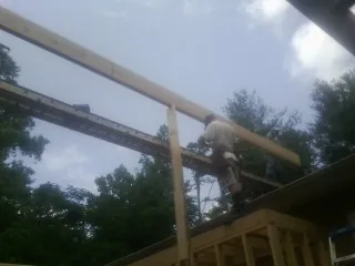Carpenter setting a ridge beam over a new addition frame — Ice Dam Removal by Roofing Brothers in Lincoln Park