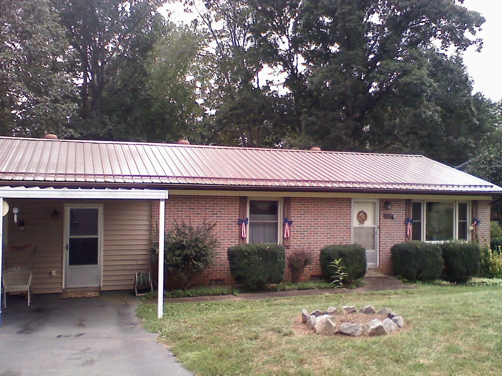 Bronze metal roof and carport on a brick ranch home — Roof Repair work by our crew in Lincoln Park