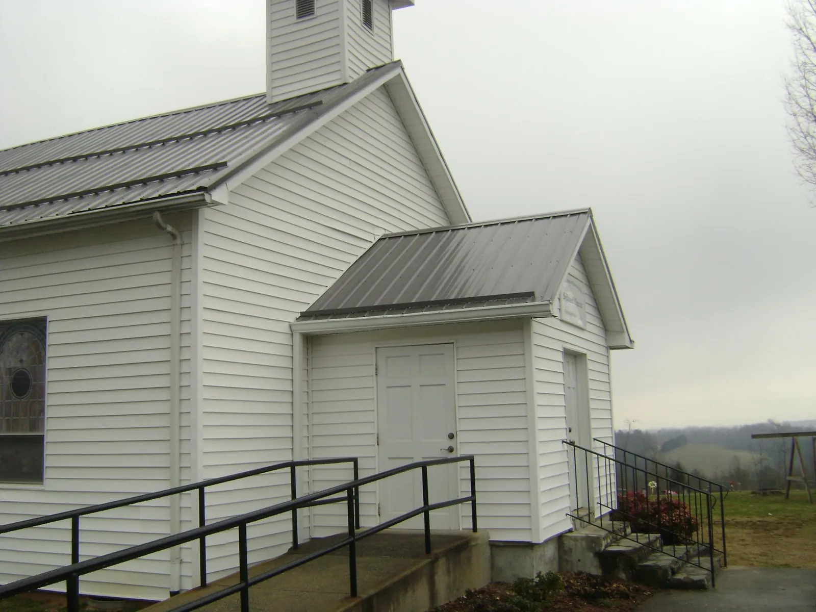 Gray metal roof on a white clapboard church with a steeple in Lincoln Park
